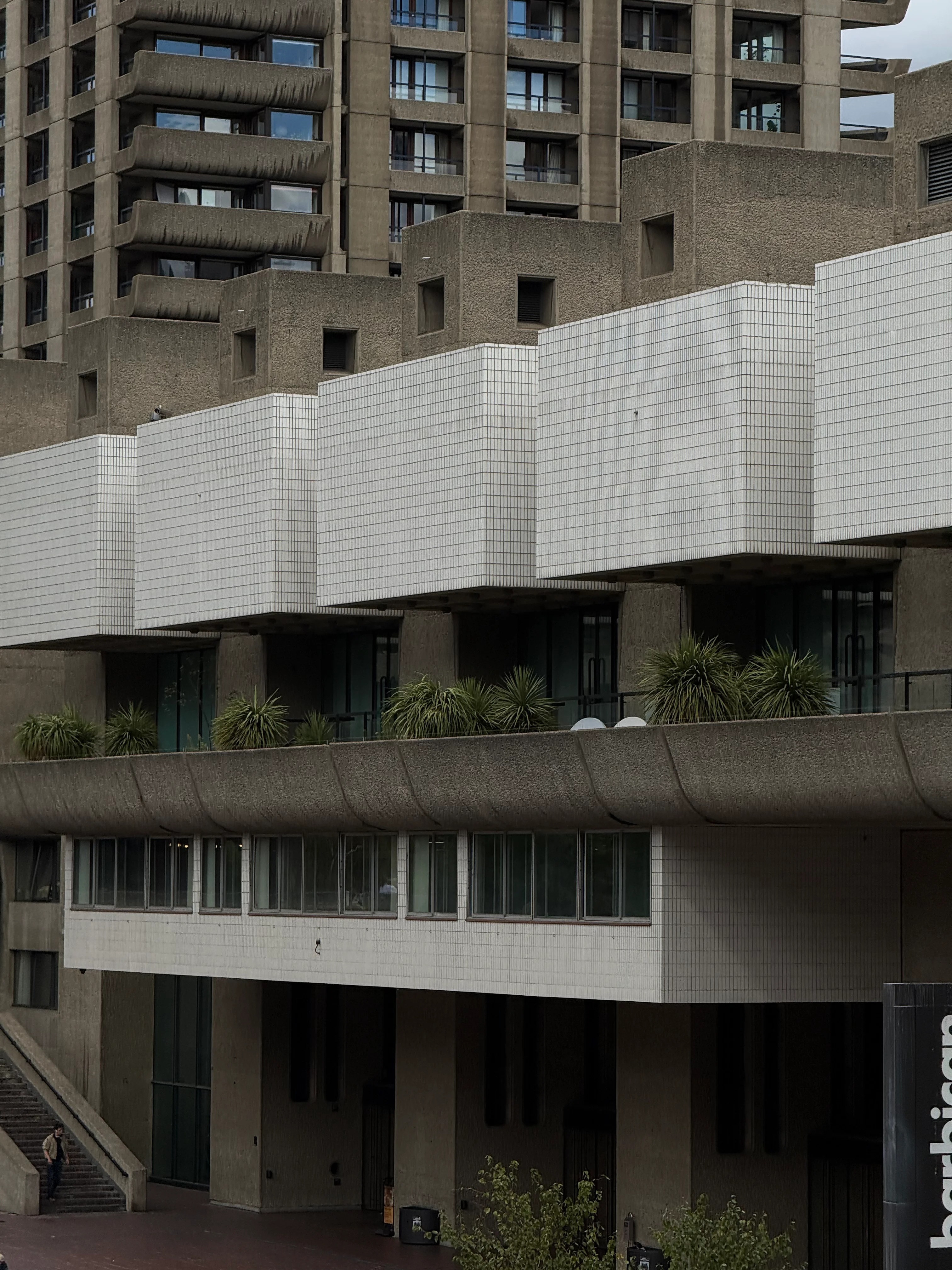 A concrete residential building with white tiled balconies.