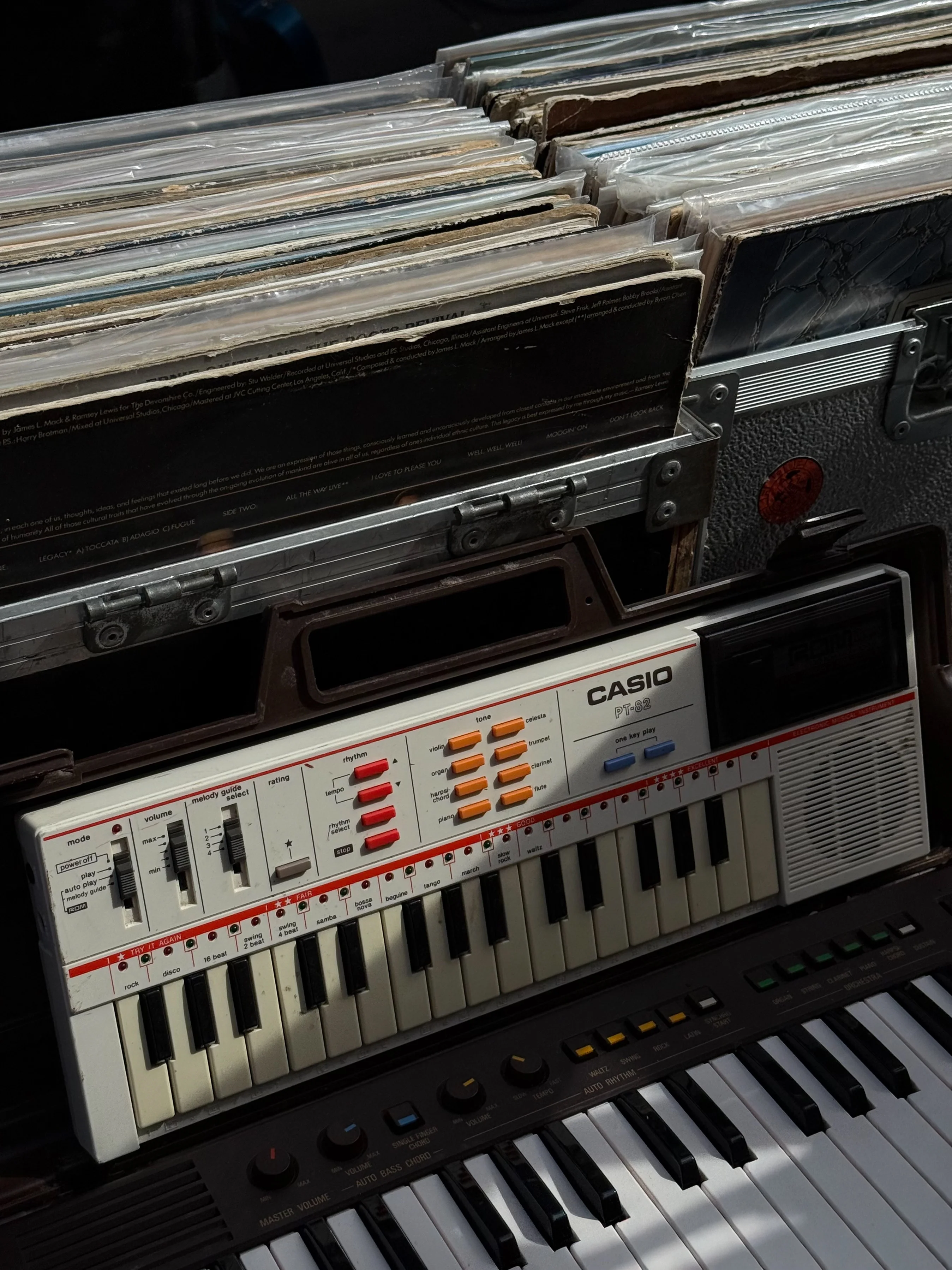 Vinyl records above a small Casio keyboard.
