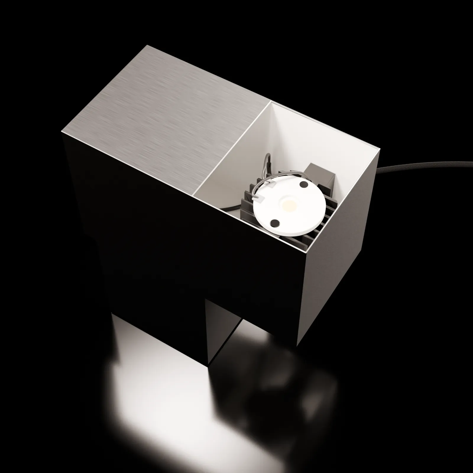 View into the aluminum lamp, showing the light source and internal construction against a dark background.