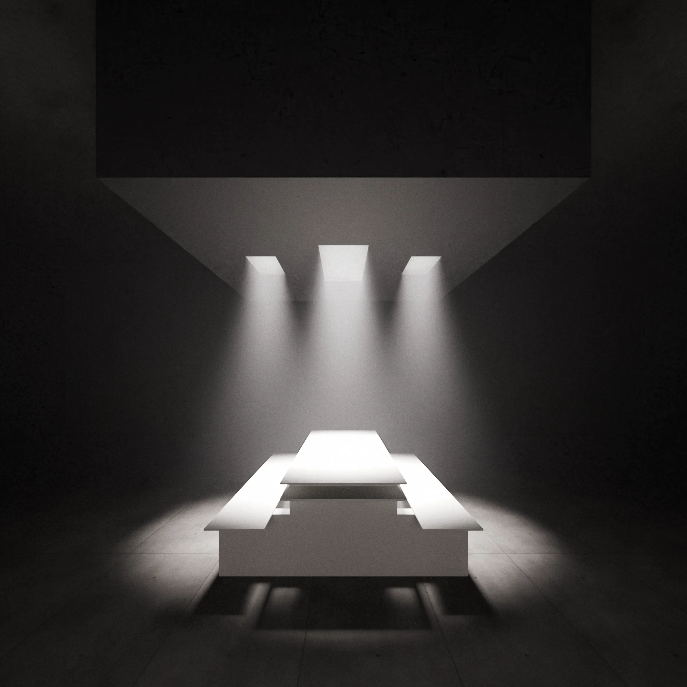 The white table and benches illuminated by three shafts of light in a dark architectural space.